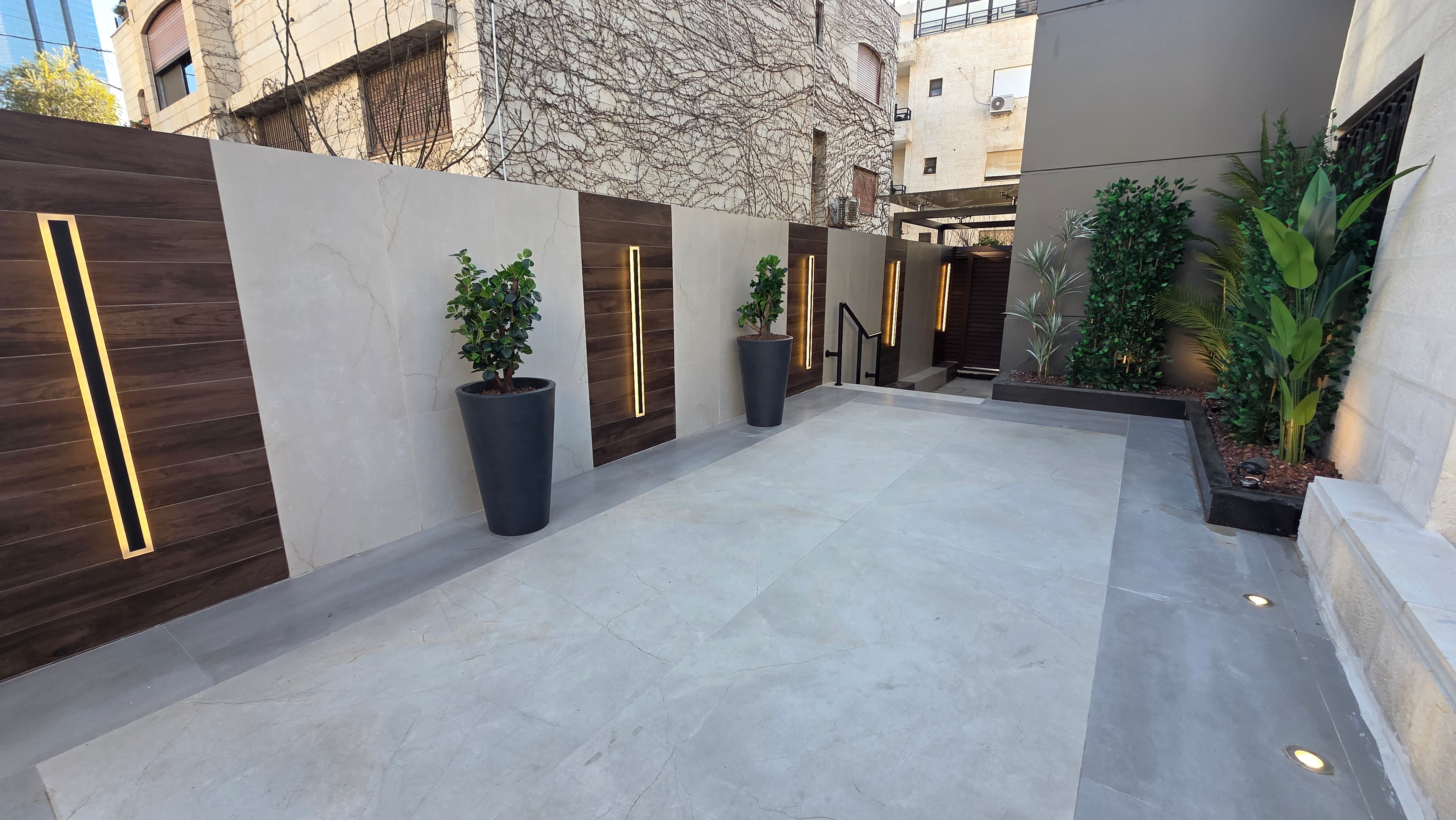 Building entrance walkway with marble panels, walnut accents, and integrated LED lighting
